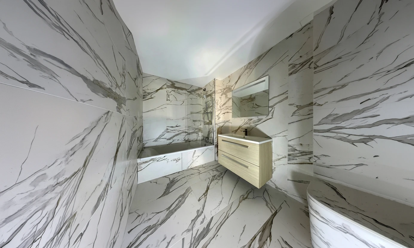 Salle de bain moderne entièrement habillée de grandes dalles effet marbre blanc veiné gris type Calacatta